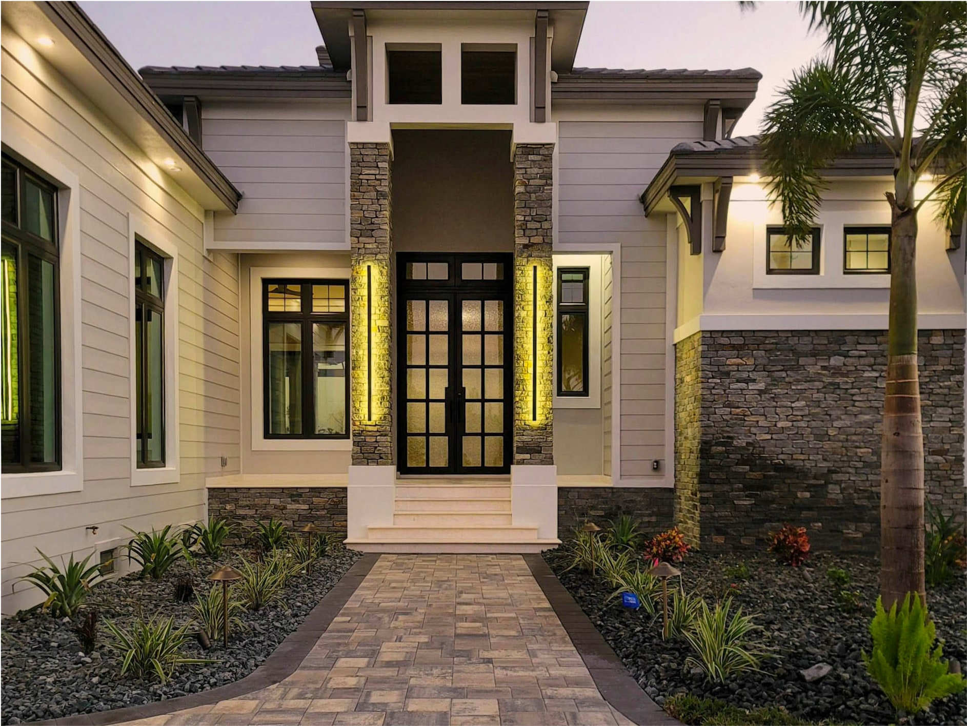 Front entry of a Naples residence with stacked-stone wing pillars