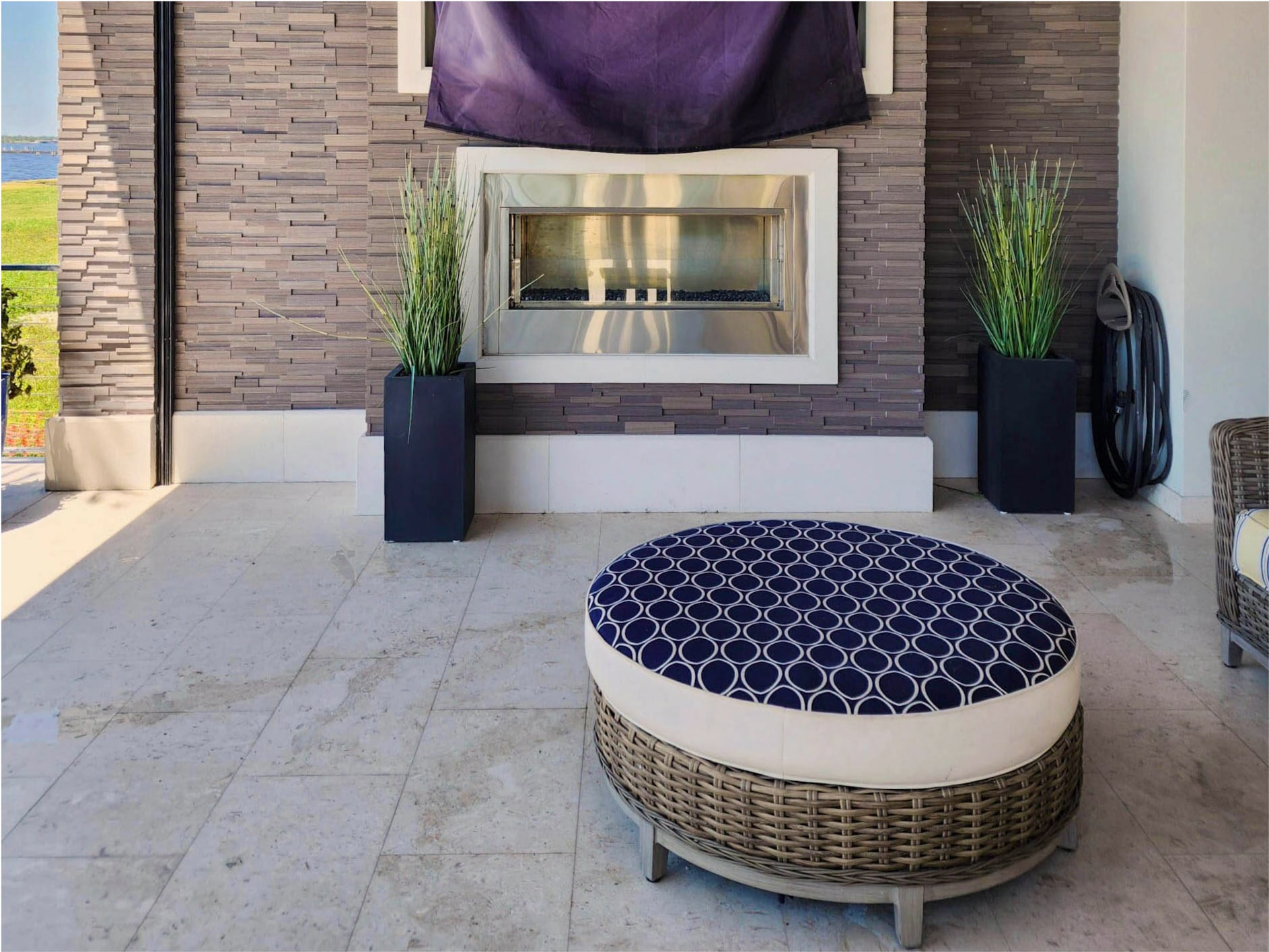 Outdoor living room with stacked stone wall and recessed fireplace